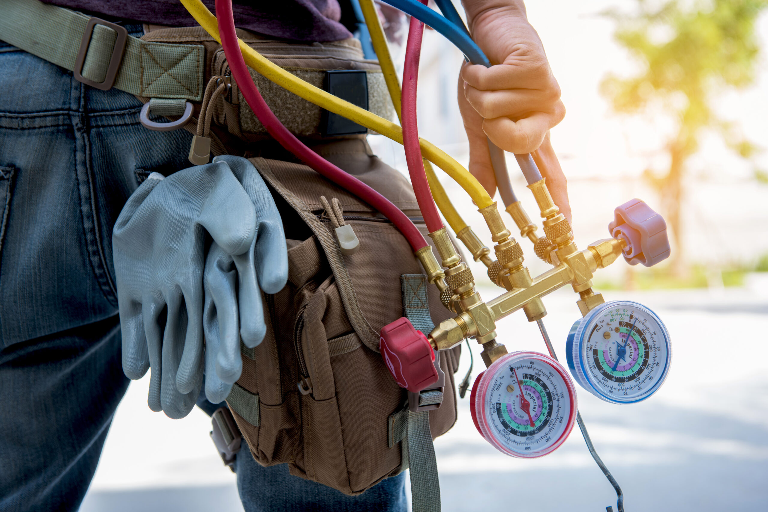 HVAC technician performing AC repair with pressure gauge